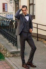 Portrait of an attractive young businessman in urban background wearing suit and a tie.