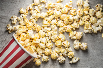 Sweet tasty popcorn in striped paper cup.