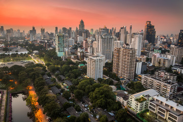 Cityscape of Bangkok, Thailand with Public Park and Skyscrapers at Sunset