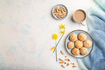 Almond cookies and a cup of coffee on a white concrete background Top view, copy space.
