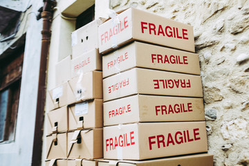 Boîtes en carton avec inscription Fragile empilées dans la rue