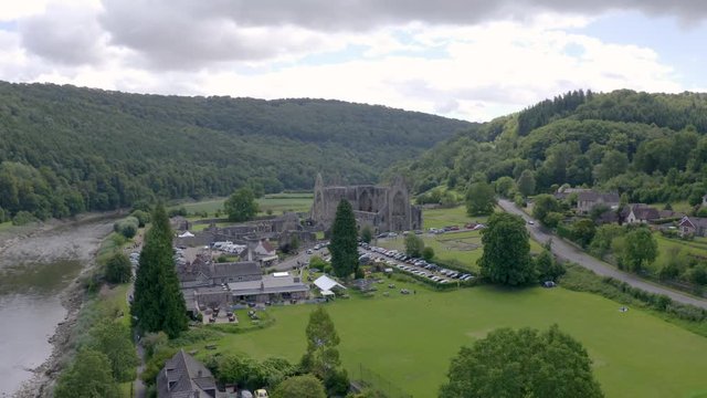 Aerial drone shot flying away from Tintern Abbey over the River Wye