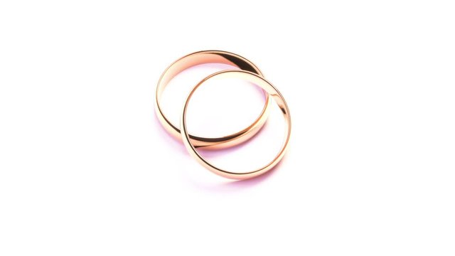 Wedding Golden Rings on white background isolated falling on isolated surface. Beautiful footage with copy space in High quality FullHD.