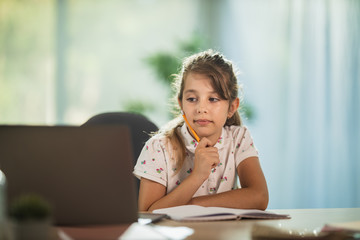 Little Girl Spending Time With Laptop And Makes Homework