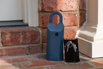 Real Estate electronic lockbox with key on a house entry porch