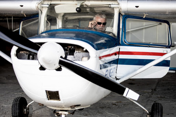 Senior man pilot checking ultralight airplane before flight
