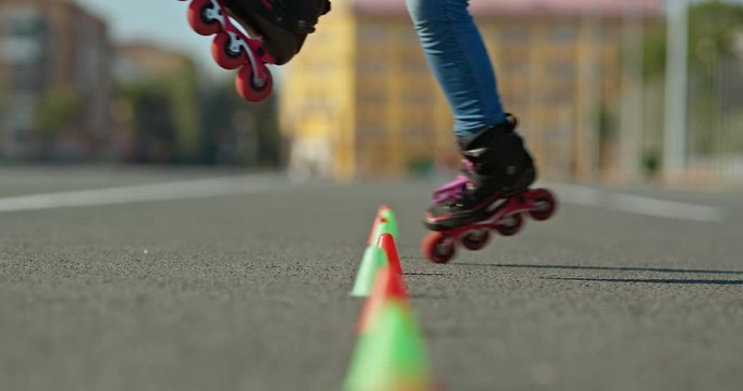 Roller skater's legs go around the cones on one skate, a professional roller sport element. Turns around on roller skates, workout outdoors. 4k, 10bit, ProRes