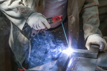 welder welds metal with a welding machine. metal works in the workshop close up. 