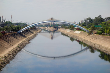 dark waters of Tiete river reflecting the sky and bridge. Sao Paulo, Brazil	