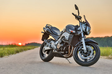 Fototapeta na wymiar beautiful black motorcycle is on the road on sunset