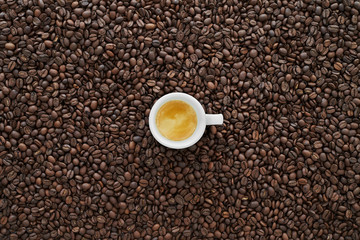 Weisse Espresso Tasse mit Kaffee Bohnen im Hintergrund. Italienischer Espresso für Kaffee Liebhaber.