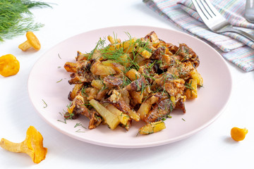 Fried forest chanterelle mushrooms with potatoes on a plate. Vegan and vegetarian dish