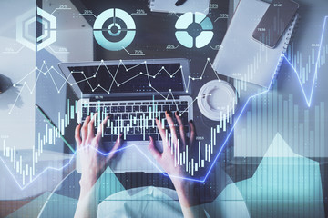 Double exposure of woman hands working on computer and forex chart hologram drawing. Top View. Financial analysis concept.