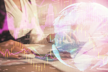 Double exposure of businesswoman hands typing on computer and forex graph hologram drawing....