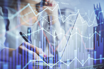 Double exposure of woman hands typing on computer and financial graph hologram drawing. Stock market analysis concept.