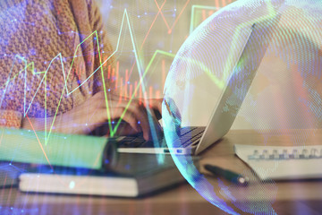 Double exposure of woman hands typing on computer and forex chart hologram drawing. Stock market...