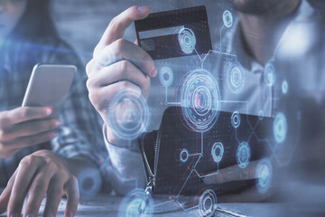 Double exposure of man and woman on-line shopping holding a credit card and data theme hologram drawing. Ai and E-commerce pay on-line concept.