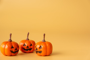 three Halloween Pumpkins on orange background