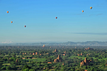 hot air balloon flying over the mountains in Bagan