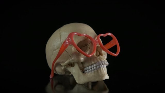 Fashion glasses for skull. Skull in red glasses with hearts, merry halloween.