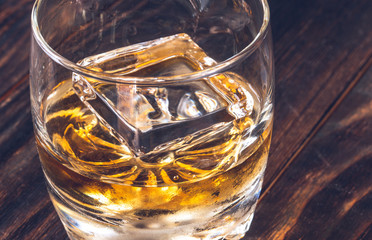 Glass of whiskey with ice cube