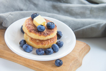 A healthy breakfast of pancakes, berries, butter, and honey
