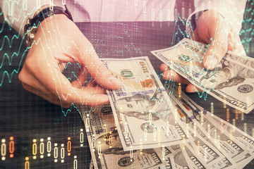 Multi exposure of financial graph drawing hologram and USA dollars bills and man hands. Analysis...