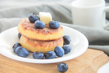 A healthy breakfast of pancakes, berries, butter, and honey