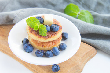 A healthy breakfast of pancakes, berries, butter, and honey