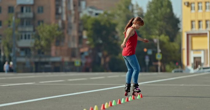 Woman athlete with overclocking makes a freestyle element, a butterfly. Professional roller skating, roller skating freestyle training. 4k, 10bit, ProRes
