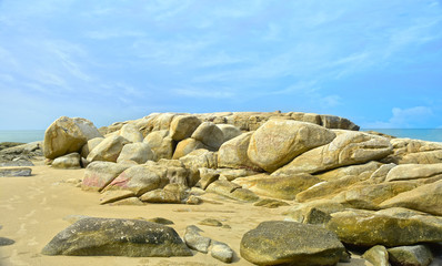 On the seashore there are many large rocks piled together.	