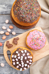 Homemade glazed and decorated easter pies on a gray wooden background and linen textile. top view, close up.