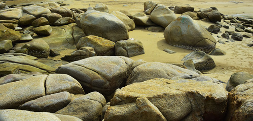 On the seashore there are many large rocks piled together.	