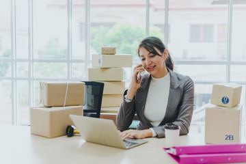 A beautiful businesswoman working at home is checking orders for products to be delivered to her...
