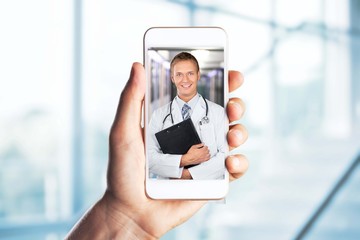 Human hand with smartphone video conferencing with doctor