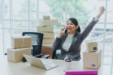 A beautiful businesswoman working at home is checking orders for products to be delivered to her...