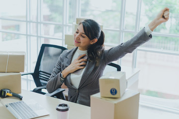 A beautiful businesswoman working at home is checking orders for products to be delivered to her...