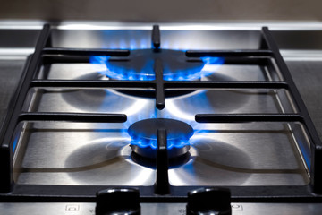 Energy Concepts. Closeup Shoot of Gas Burner on Stove Surface with Fire Flames.