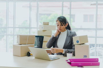 A beautiful businesswoman working at home is checking orders for products to be delivered to her...
