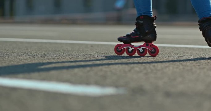 Legs of a girl in roller skates, a roller puts cones in a row on the asphalt, the beginning of a workout. Professional training of a roller skater, close-up. 4k, 10bit, ProRes