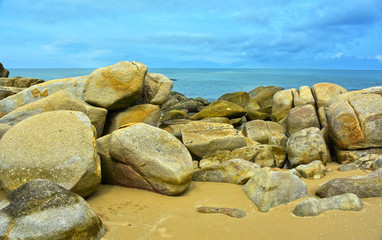 
On the seashore there are many large rocks piled together.