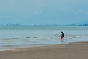 
On the beach a man rowing on the sea.