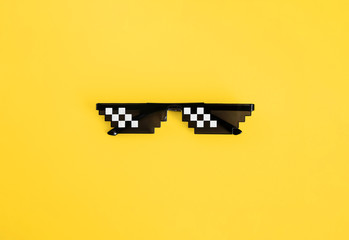 Funny pixelated boss sunglasses on yellow background