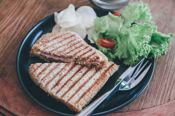 Delicious Healthy Grill sandwich ham cheese and salad ( lettuce, ham, cheese, tomato and potato chip)with a cup of coffee.Breakfast meal.