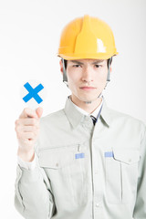 バツのプラカードを持った男性作業員