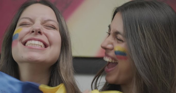 Beautiful Wide Smile Of Two Young Colombian Women Holding A Colombia National Flag - Slow Motion