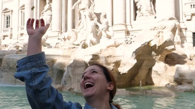 Woman fails to throw coin into fountain in slow motion, Rome, Italy