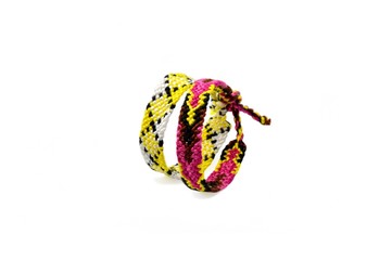Selective focus of tied woven friendship bracelets with bright colorful pattern handmade of thread isolated on white background