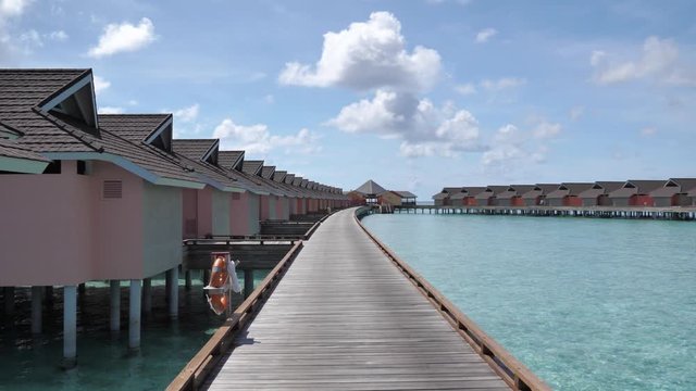 Luxury apartments built over shallow blue water with wooden walkways