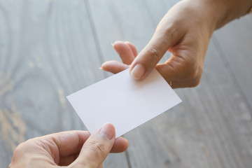 Obraz premium Hand holding Business card on a wood background